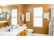 Well-lit bathroom featuring a vanity with sink, toilet, and towel rack at 10952 S Desert Lake Dr, Goodyear, AZ 85338