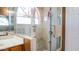 Tiled walk-in shower featuring glass door and small tiled shower bench at 10952 S Desert Lake Dr, Goodyear, AZ 85338