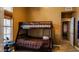 Bedroom with a bunk bed, tile flooring, and a window providing natural light at 10952 S Desert Lake Dr, Goodyear, AZ 85338