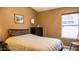 Bedroom with neutral walls, a queen bed, a window, and a dresser at 10952 S Desert Lake Dr, Goodyear, AZ 85338