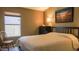 Bedroom with neutral colored walls, window with blinds, bed, and lamp at 10952 S Desert Lake Dr, Goodyear, AZ 85338
