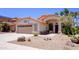 Attractive desert home with a terracotta roof, a two-car garage, and desert landscaping with native plants at 10952 S Desert Lake Dr, Goodyear, AZ 85338