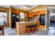 Well-lit kitchen with custom wood cabinets, granite countertops, an island with seating and stainless steel appliances at 10952 S Desert Lake Dr, Goodyear, AZ 85338