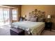 Comfortable bedroom featuring a decorative headboard, bay window, and sliding door, providing a relaxing retreat at 10952 S Desert Lake Dr, Goodyear, AZ 85338