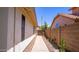 Charming walkway with desert landscaping leading to a gated entrance and light beige exterior walls at 10952 S Desert Lake Dr, Goodyear, AZ 85338