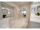 Bright primary bathroom featuring dual sinks, a large mirror, and a view of the bedroom at 1132 E Sheffield Ave, Chandler, AZ 85225