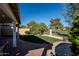 Well-maintained backyard featuring lush green grass, mature trees, and a view of the golf course at 1227 E Sheena Dr, Phoenix, AZ 85022