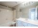 Bright bathroom features a shower-tub combo, white vanity, and a large mirror reflecting an open doorway at 1227 E Sheena Dr, Phoenix, AZ 85022