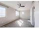 This bedroom features a ceiling fan, neutral paint and carpet, and three windows providing plenty of sunlight at 1227 E Sheena Dr, Phoenix, AZ 85022