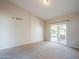 Bright bedroom with neutral walls, carpet flooring, and a sliding glass door to the patio at 1227 E Sheena Dr, Phoenix, AZ 85022