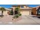 Inviting tan two-story home featuring a two-car garage, desert landscaping, and a tile roof at 1227 E Sheena Dr, Phoenix, AZ 85022