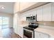 Bright kitchen features stainless steel appliances, white cabinets and access to the backyard through sliding glass doors at 1227 E Sheena Dr, Phoenix, AZ 85022