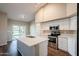Bright kitchen features an island, stainless steel appliances, white cabinets and sliding glass doors to the yard at 1227 E Sheena Dr, Phoenix, AZ 85022