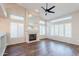 Living room featuring a fireplace, wood floors, ceiling fan, and many windows at 1227 E Sheena Dr, Phoenix, AZ 85022