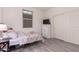 Bedroom featuring neutral walls, wood-look tile, and a closet, offering storage and style at 12565 W Palmaire Ave, Glendale, AZ 85307