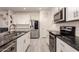 Well-appointed kitchen featuring modern appliances, granite countertops, and stylish white cabinetry at 12565 W Palmaire Ave, Glendale, AZ 85307