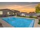 Backyard features a sparkling in-ground pool, perfect for relaxing and entertaining with landscape and sunset view at 12565 W Palmaire Ave, Glendale, AZ 85307