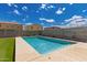 Relaxing backyard with a pool, turf, and string lights perfect for outdoor enjoyment at 12565 W Palmaire Ave, Glendale, AZ 85307