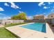 Sparkling pool amidst lush turf, creating a serene backyard retreat under a blue sky at 12565 W Palmaire Ave, Glendale, AZ 85307