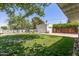 Landscaped backyard features green lawn with flowers, detached garage, and privacy fence at 1306 W Heatherbrae Dr, Phoenix, AZ 85013