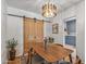 Elegant dining room with a wooden table, modern chairs, a contemporary light fixture, and stylish barn doors at 1306 W Heatherbrae Dr, Phoenix, AZ 85013