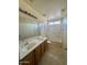 A well-lit bathroom featuring a double vanity, tiled floors, and a shower/tub combo at 1352 S 221St Ln, Buckeye, AZ 85326