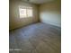 Bedroom featuring neutral walls, tile flooring, and a large window at 1352 S 221St Ln, Buckeye, AZ 85326