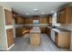Open-concept kitchen with oak cabinets, center island, and modern appliances at 1352 S 221St Ln, Buckeye, AZ 85326