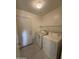 Practical laundry area with washer, dryer, and storage shelving at 1352 S 221St Ln, Buckeye, AZ 85326