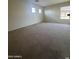 Spacious living room featuring soft carpet and ample natural light at 1352 S 221St Ln, Buckeye, AZ 85326