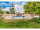 Community pool with chairs behind white fence and lush lawn offering residents a relaxing outdoor oasis at 14402 N 58Th Dr, Glendale, AZ 85306