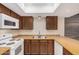Kitchen with white appliances, wood cabinets, and tile backsplash at 14402 N 58Th Dr, Glendale, AZ 85306