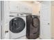 Well-equipped laundry room with a washer, dryer, and overhead cabinets at 14402 N 58Th Dr, Glendale, AZ 85306