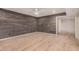 Spacious living room featuring wood accent wall, ceiling fan, and light hardwood floors at 14402 N 58Th Dr, Glendale, AZ 85306