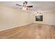 Open-concept living area with laminate floors, neutral paint, ceiling fan, and a window at 14402 N 58Th Dr, Glendale, AZ 85306