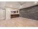 Open living area with laminate floors, a unique wood accent wall, and a pass-through to the kitchen at 14402 N 58Th Dr, Glendale, AZ 85306