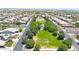 A beautiful aerial view of a neighborhood park featuring a large grassy area, mature trees, and walking paths at 14408 W Bloomfield Rd, Surprise, AZ 85379