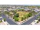 Aerial view of a neighborhood park, showcasing a large grassy area, playground equipment, and mature trees at 14408 W Bloomfield Rd, Surprise, AZ 85379