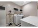 Modern laundry room with washer, dryer, and ample counter space at 14408 W Bloomfield Rd, Surprise, AZ 85379
