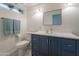 Well-lit bathroom featuring a blue vanity, contemporary mirror, and green plants for added aesthetics at 14624 N 44Th St, Phoenix, AZ 85032