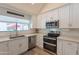Well-lit kitchen featuring stainless steel appliances, white cabinetry, and sleek countertops at 14624 N 44Th St, Phoenix, AZ 85032