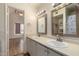 Bathroom featuring double sinks and mirrors, cabinetry, and view to adjacent bedroom at 1535 N Horne -- # 67, Mesa, AZ 85203