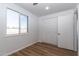 Bedroom features wood-look floors, white walls, closet with bi-fold doors, and a window at 1550 W Willow Ave, Phoenix, AZ 85029