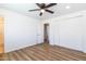 Bedroom features wood-look floors, white walls, closet with bi-fold doors, and an ensuite bathroom at 1550 W Willow Ave, Phoenix, AZ 85029