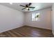 Bright bedroom features wood-look floors, white walls, a ceiling fan, and a window with a view of the outdoors at 1550 W Willow Ave, Phoenix, AZ 85029