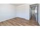 Bedroom features wood-look floors, white walls, closet with bi-fold doors, and doorway to the hallway at 1550 W Willow Ave, Phoenix, AZ 85029