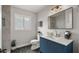 Bathroom featuring a tiled shower, white toilet and vanity with blue cabinets at 1615 E Fremont Dr, Tempe, AZ 85282