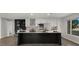 Modern kitchen featuring white cabinets, a black island, stainless steel appliances, and views to the front yard at 1615 E Fremont Dr, Tempe, AZ 85282