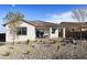 Cozy covered patio with outdoor dining set, complemented by a well-maintained gravel yard and landscaping at 17383 W Fallen Leaf Ln, Surprise, AZ 85387