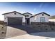 Beautiful single-story home boasting a well-manicured lawn and an inviting facade with stone accents at 17383 W Fallen Leaf Ln, Surprise, AZ 85387